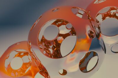 A close up of three shiny objects on a white surface
